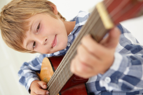 A Child learning to play guitar.